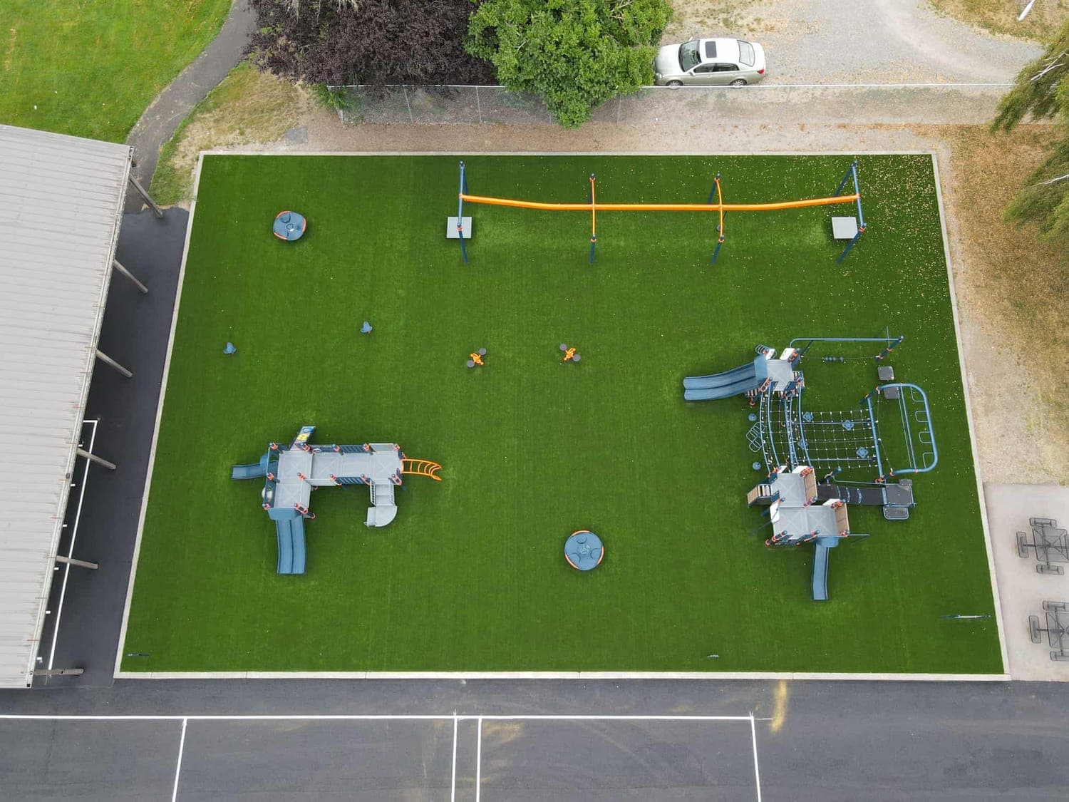 Aerial view of a commercial playground with artificial turf safety surfacing and play structures