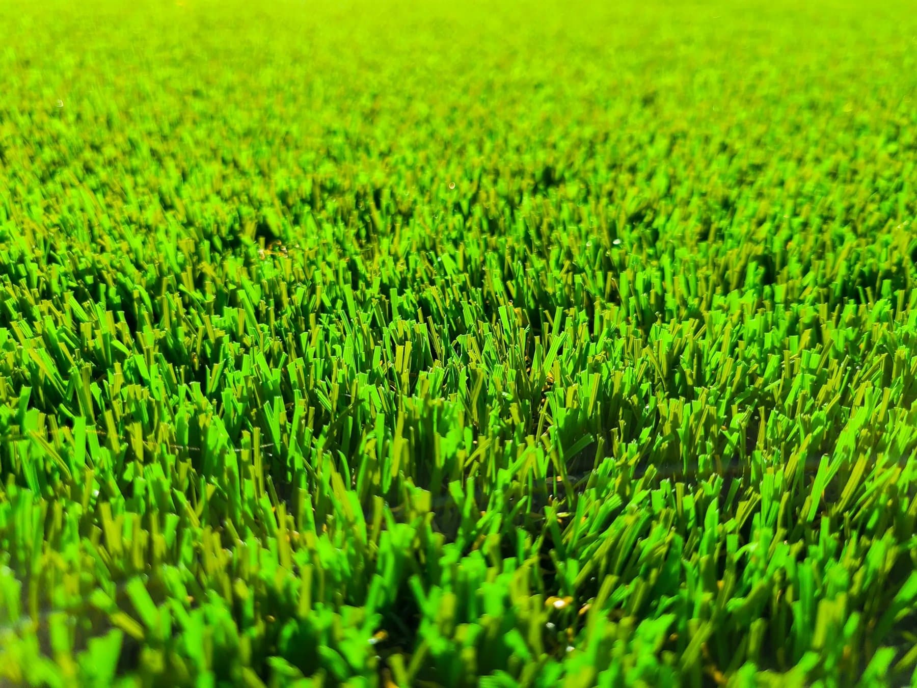 Close-up of dense premium synthetic grass blades used for artificial lawn installations